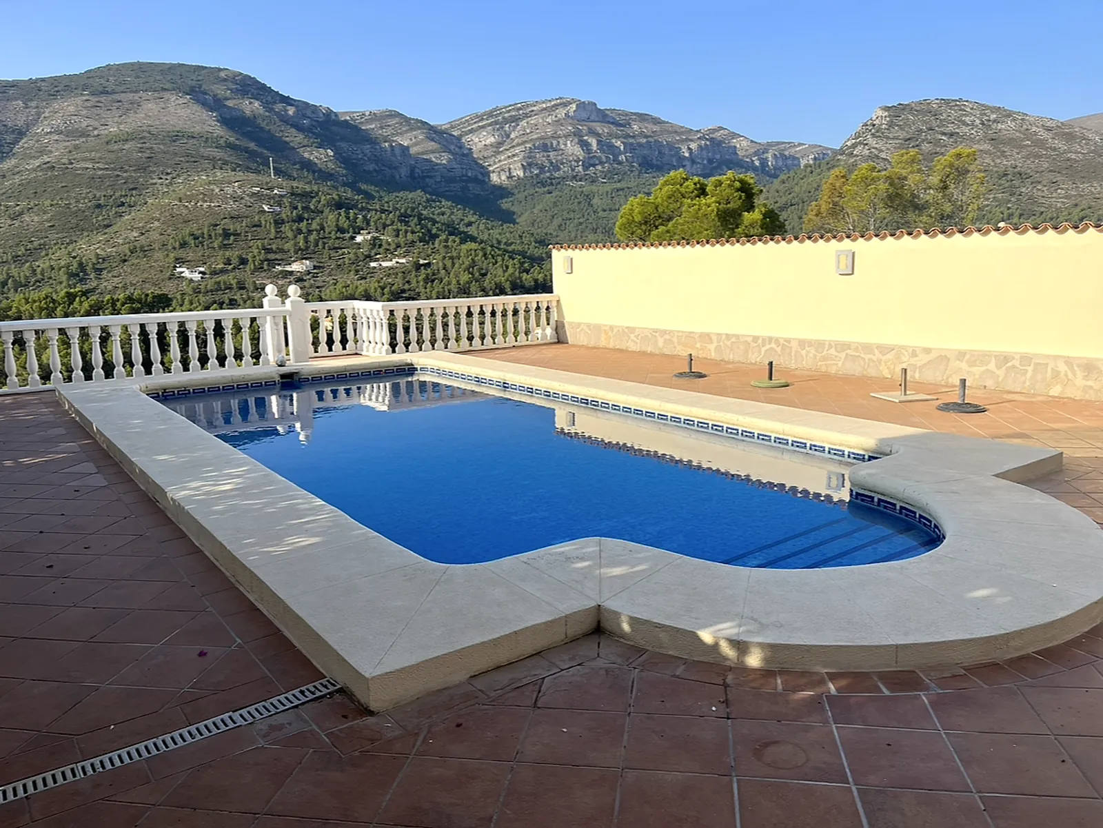 Before: pool with worn, discoloured cream stone coping