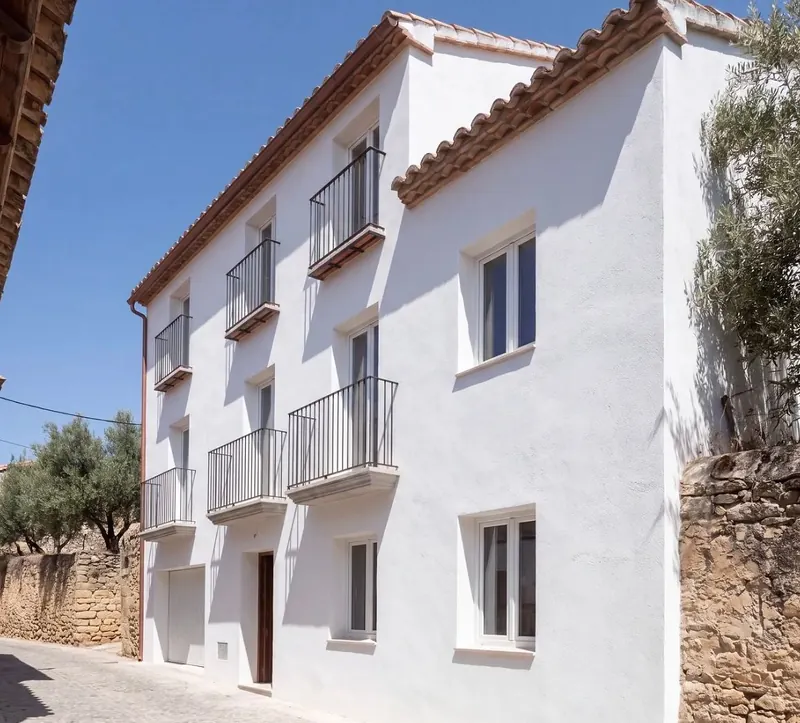 House with smooth white render, iron balconies and terracotta roof tiles