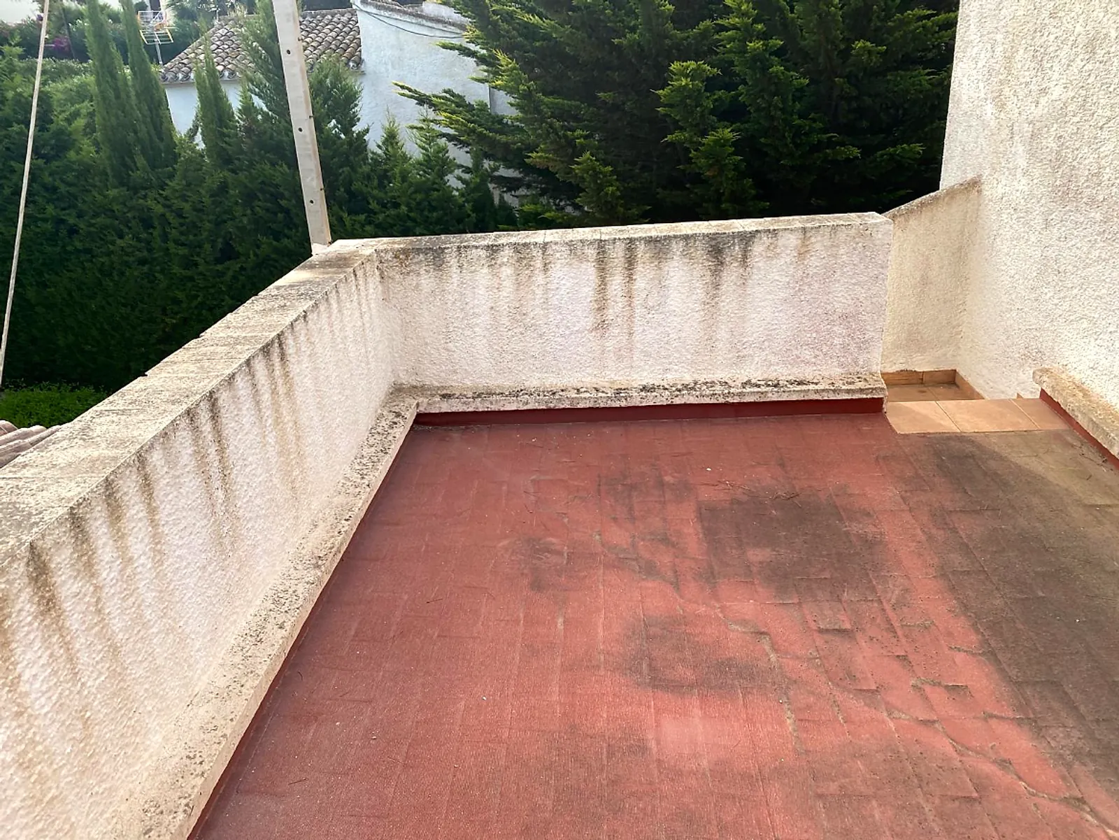 Before: roof terrace walls stained with dirt and water streaks