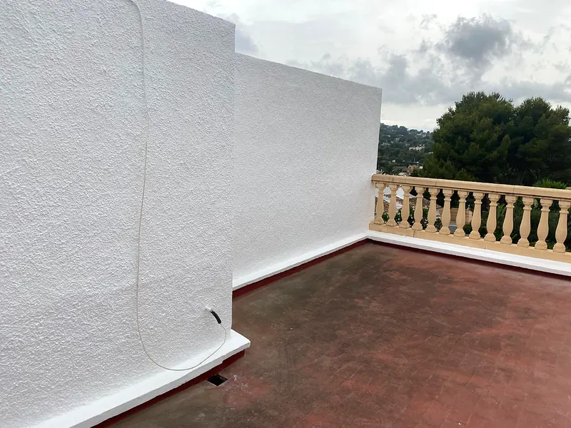 Freshly rendered white terrace walls with a stone balustrade
